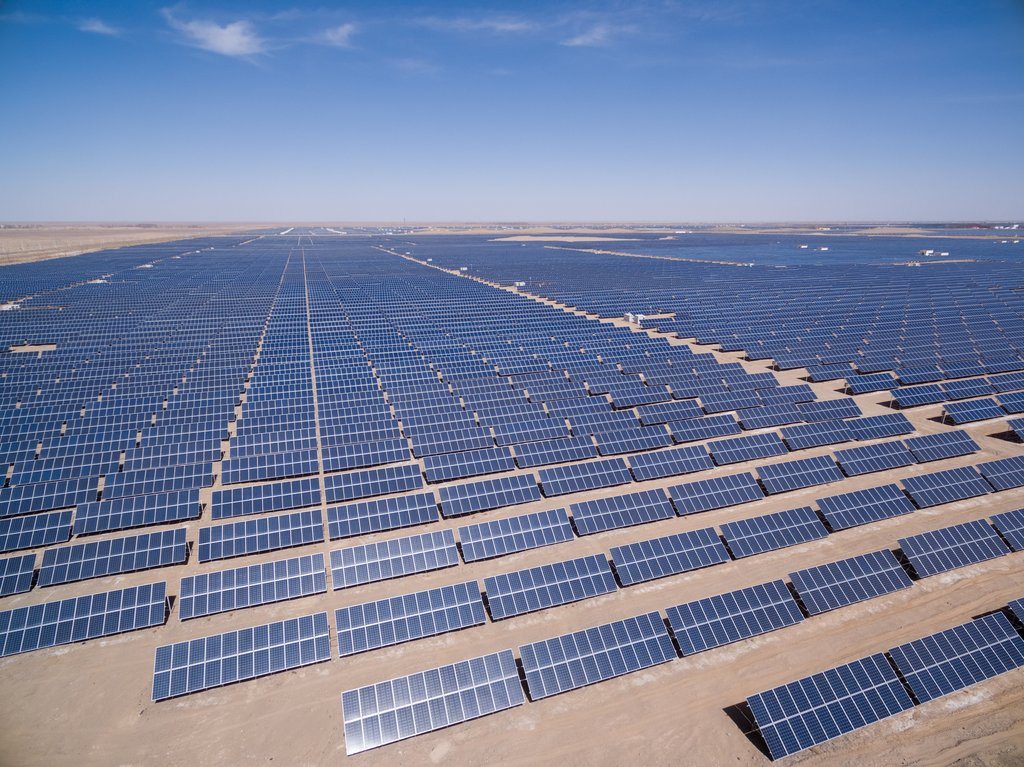 Aerial view of solar arrays in the desert at sunset